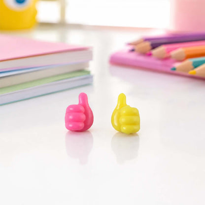 Pink and yellow thumb wire holder both colors on desk